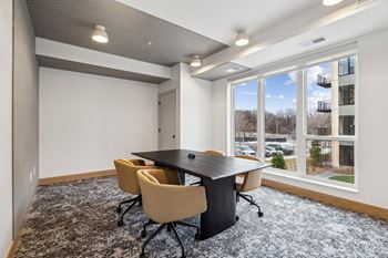 A conference room with a large table and chairs.